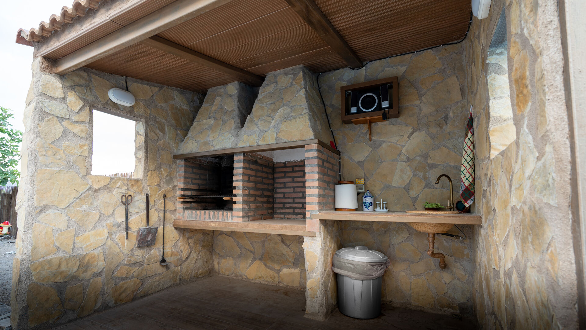 Zona de barbacoa cubierta con cocina exterior completa